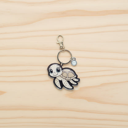 Keychain with a sea turtle design on a wood background